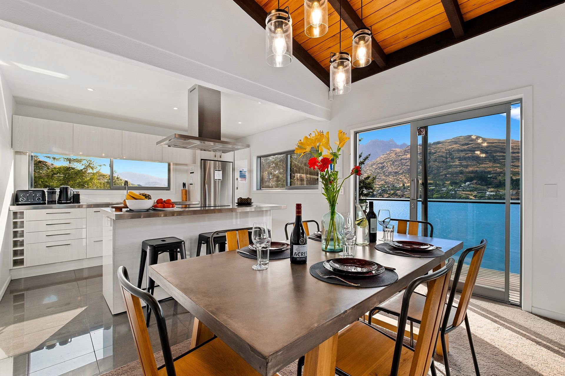 Dining area and kitchen with lake views at Queenstown Lakefront Dream, Queenstown