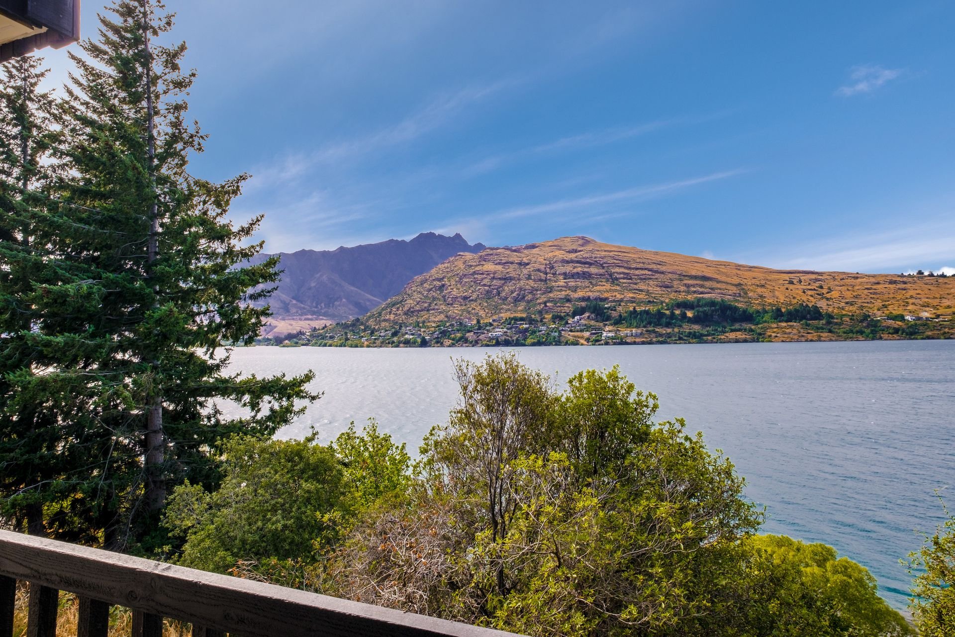 Lake Whakatipu seen through the trees from the deck at Queenstown Lakefront Dream, Queenstown