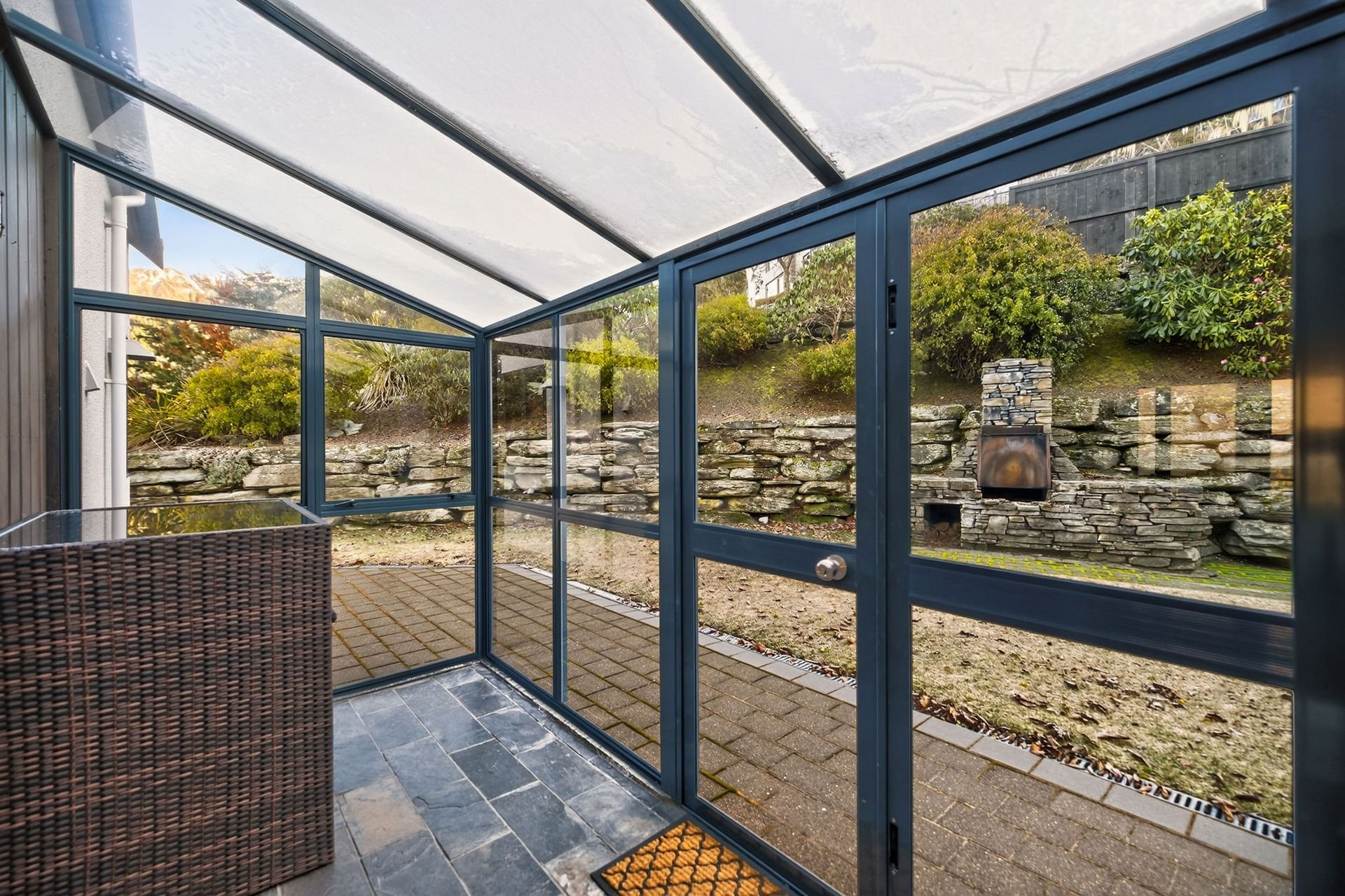 Glazed sun room opening to the terrace at Alpine Haven, Queenstown