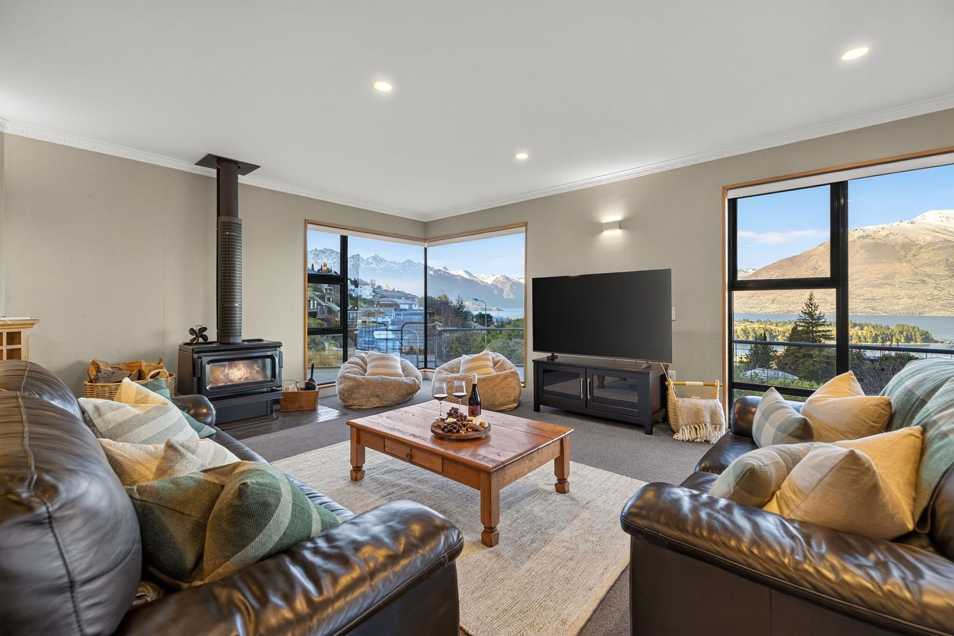 Lounge with fireplace and lake views at Alpine Haven, Queenstown