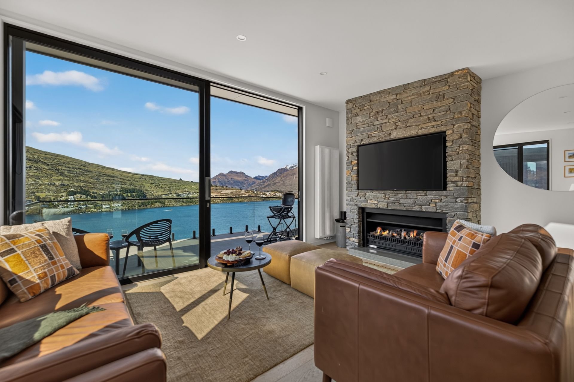 Lounge with fireplace and lake views at Woods Villa Tui, Queenstown