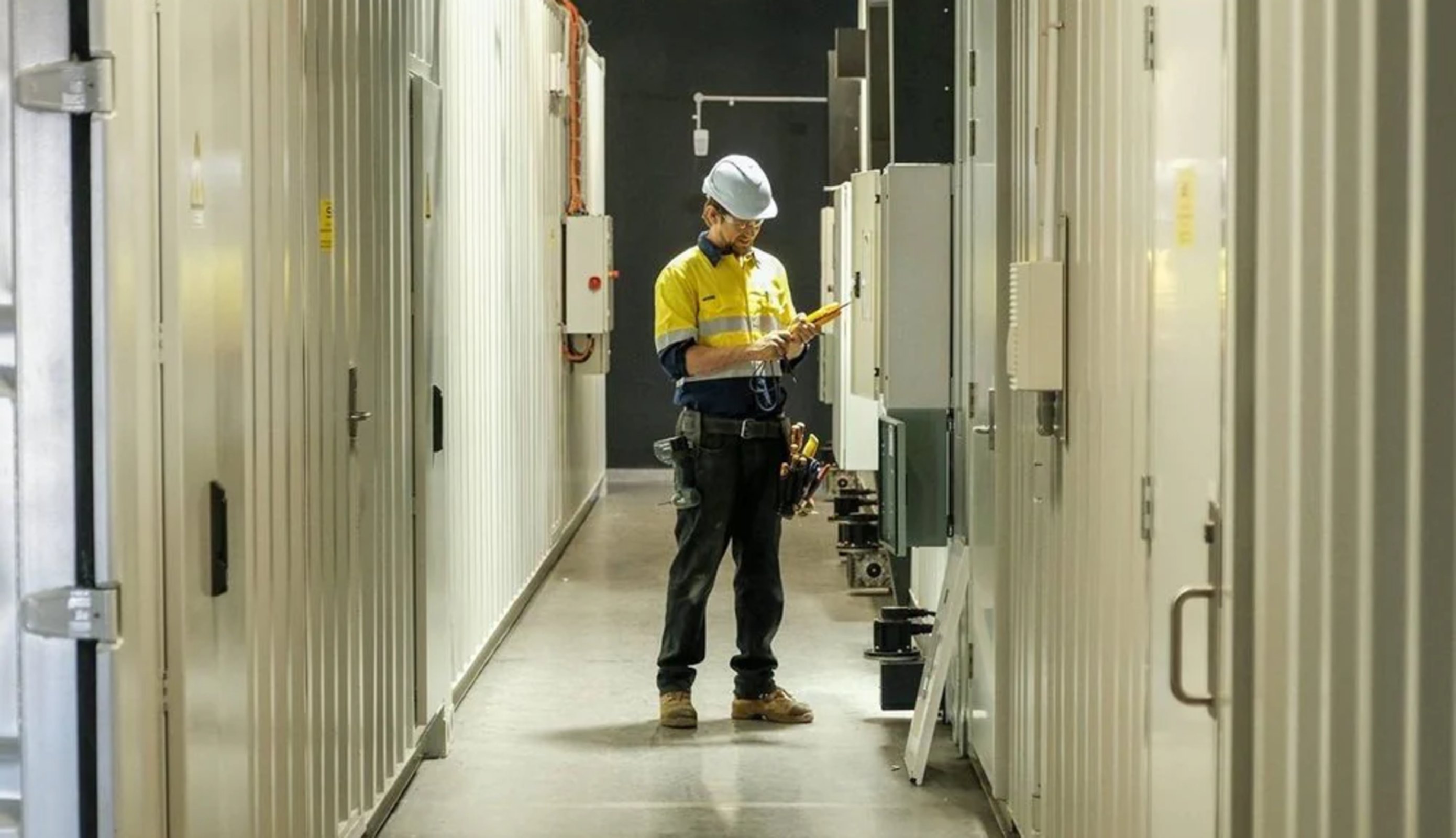 Technician inspecting modular data centre infrastructure
