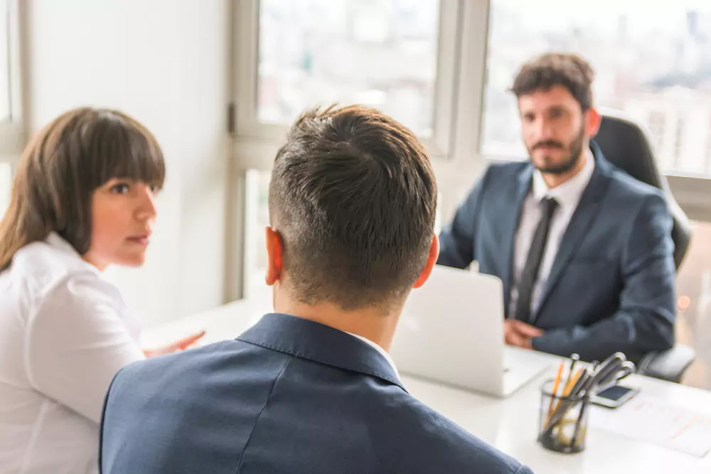 Hombre de negocios y mujer de negocios sentados frente al gerente en el lugar de trabajo