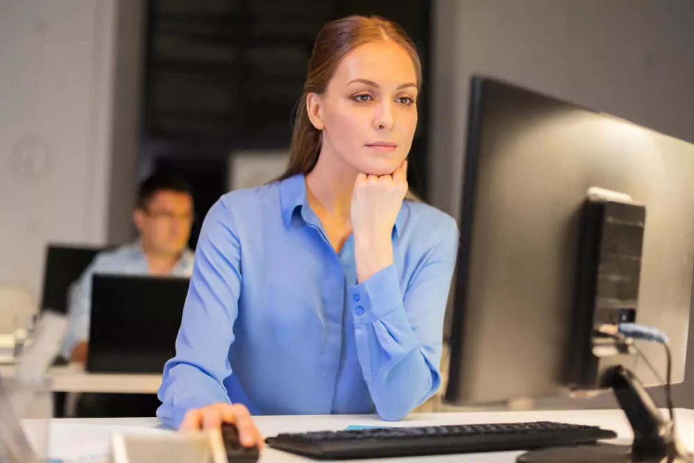 Mujer de negocios trabajando en la computadora en la oficina por la noche