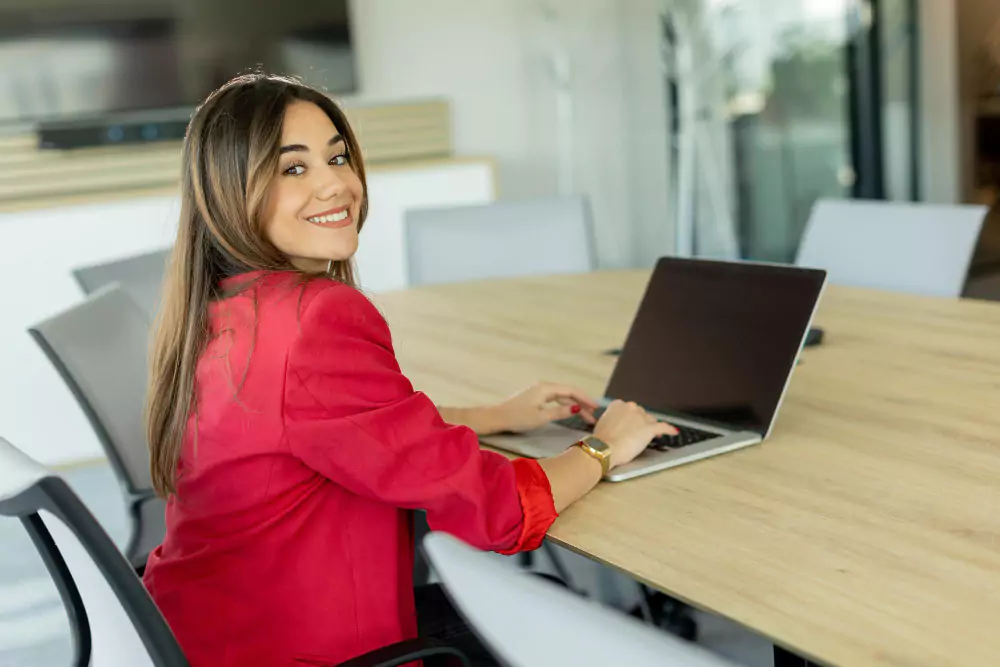 Mujer de negocios confiada sonriendo durante una reunión matutina en una oficina moderna