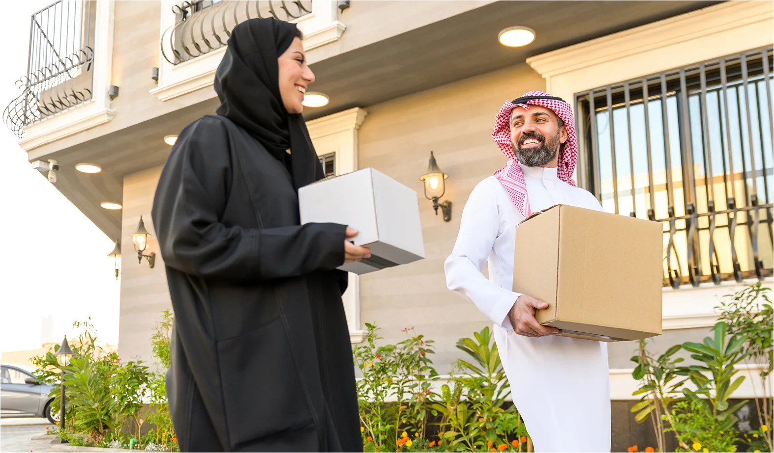 A woman and a man holding delivery boxes