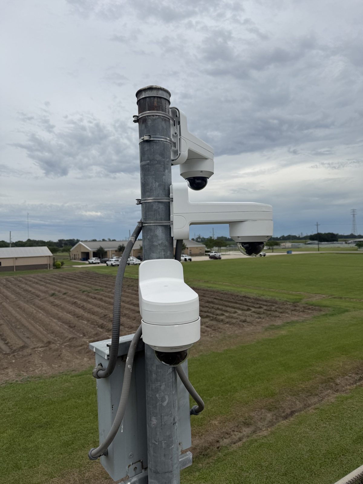 Pole-mounted IP cameras and an equipment enclosure at a secure facility