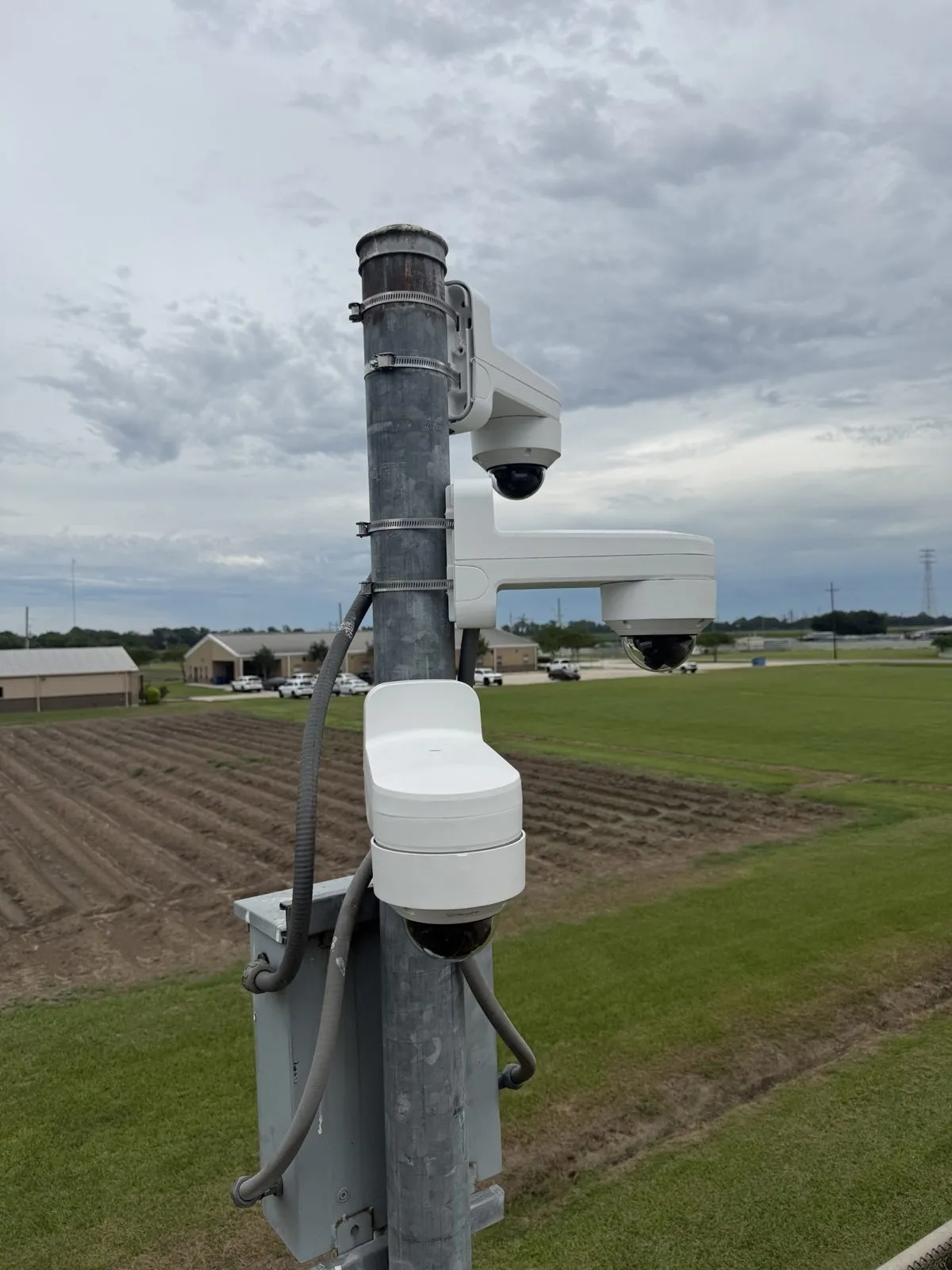 Pole-mounted IP cameras and an equipment enclosure at a secure facility
