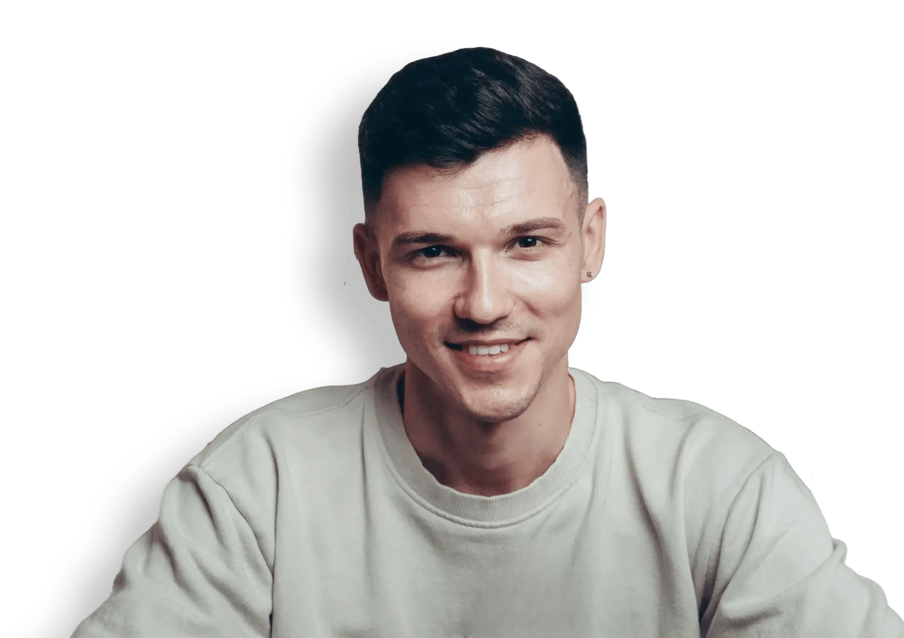 Smiling young man with short dark hair wearing a light grey sweatshirt.