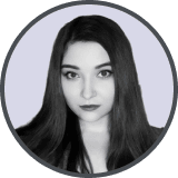 Black and white portrait of a woman with long dark hair and a neutral expression.