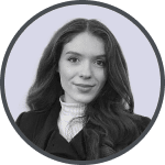 Black and white headshot of a woman with long hair wearing a dark blazer and white turtleneck.