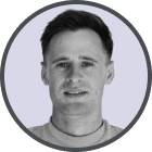 Portrait of a young man with short dark hair and a neutral expression against a light background.