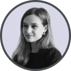 Black and white portrait of a woman with long hair wearing earrings and a dark top, looking slightly to the side.