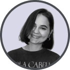 Smiling woman with short dark hair wearing hoop earrings and a dark top.