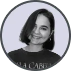 Smiling woman with short dark hair wearing hoop earrings and a dark top.