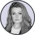 Black and white portrait of a woman with long hair and a serious expression, wearing a light top and a dark jacket.