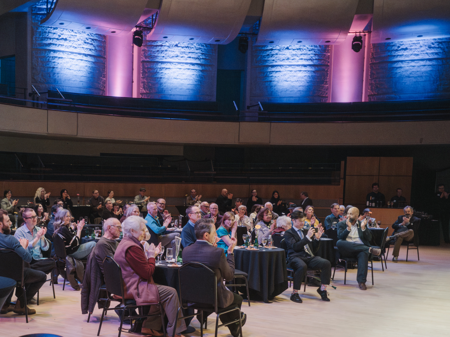 Guests seated on stage listen to speakers
