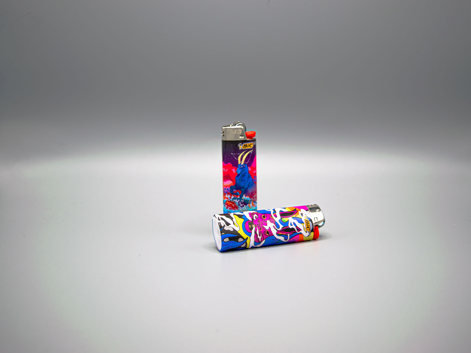 A picture of a colorfull Bic lighter, one upright, one on its side