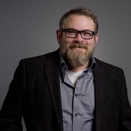 A professional headshot of Matthew Nelson