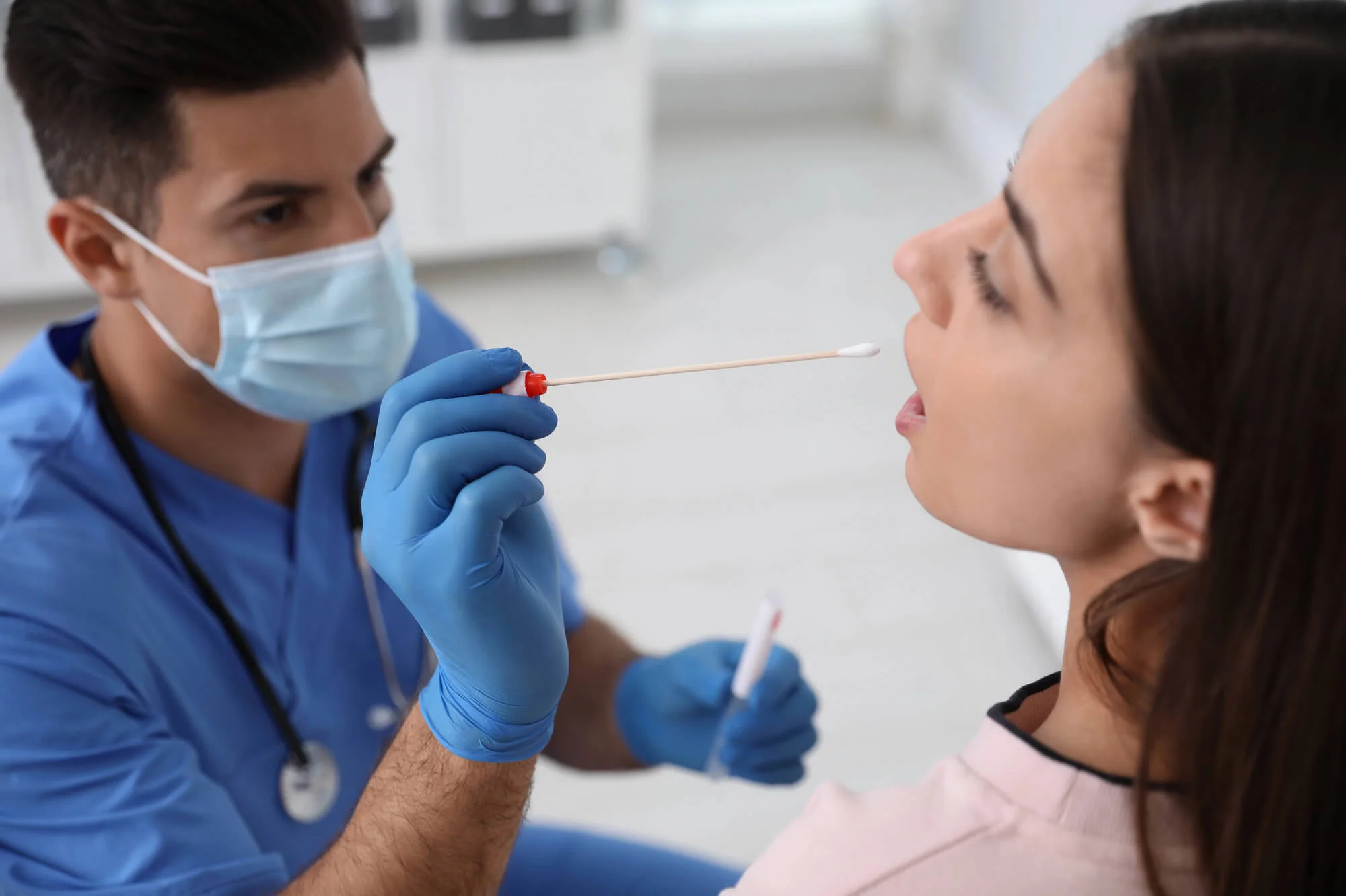 Dentist collecting saliva sample for oral DNA testing in Virginia during preventive dental exam