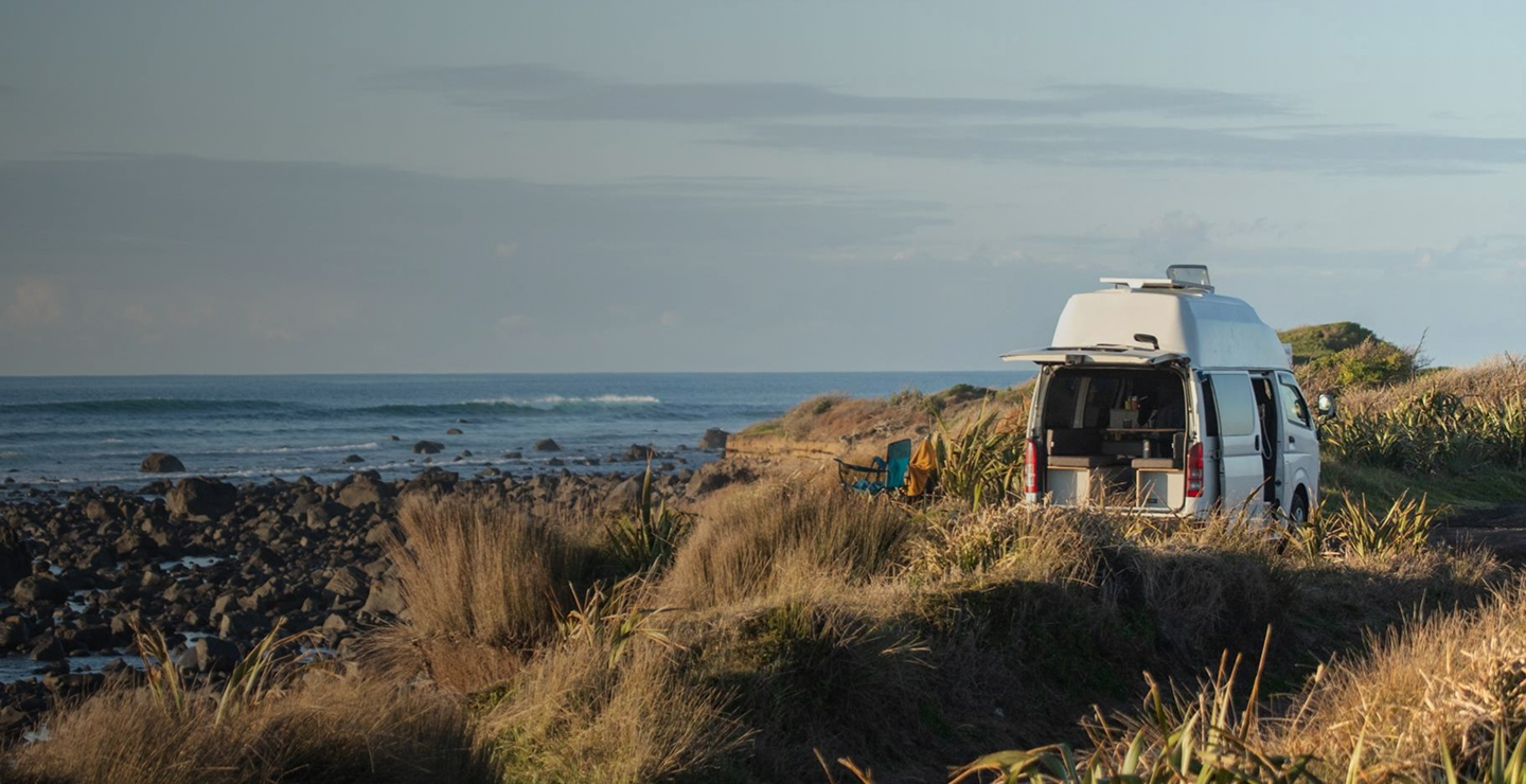 Self-contained campervan freedom camping on a Northland coastal reserve