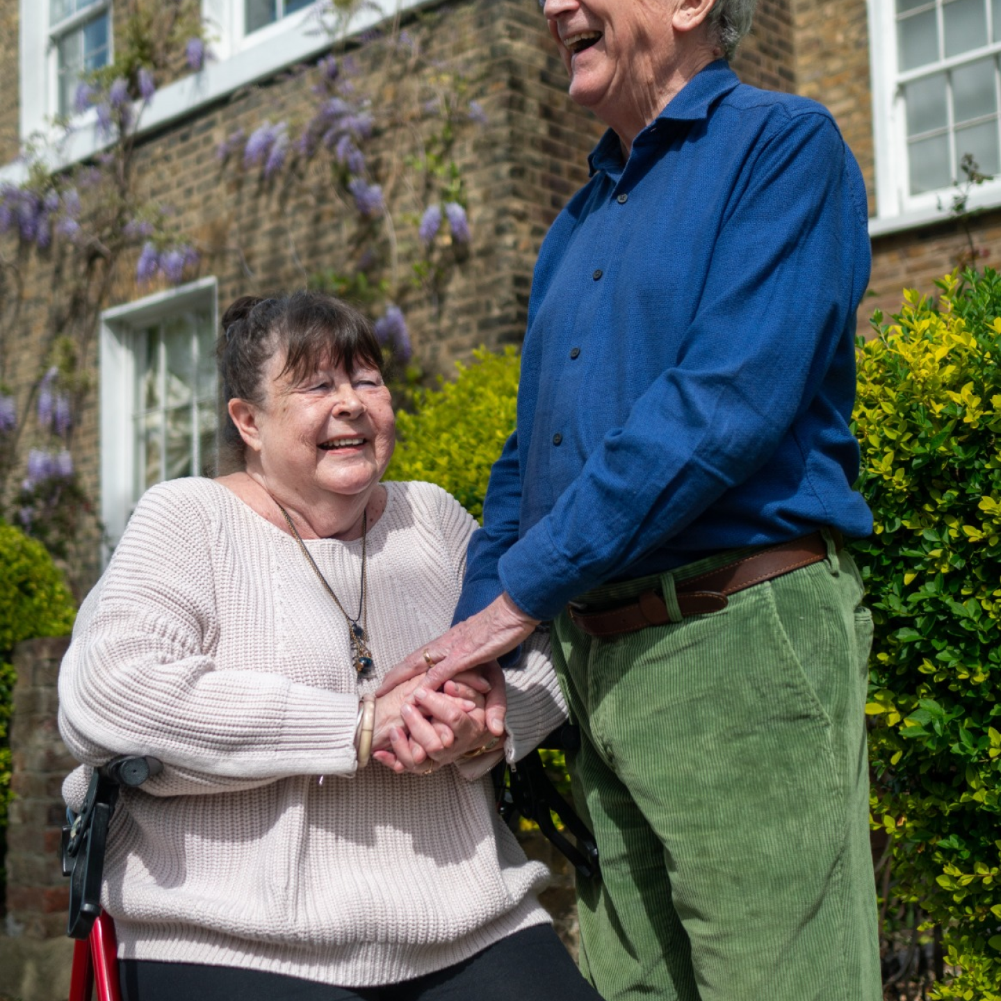 Two elderly people holding hands.
