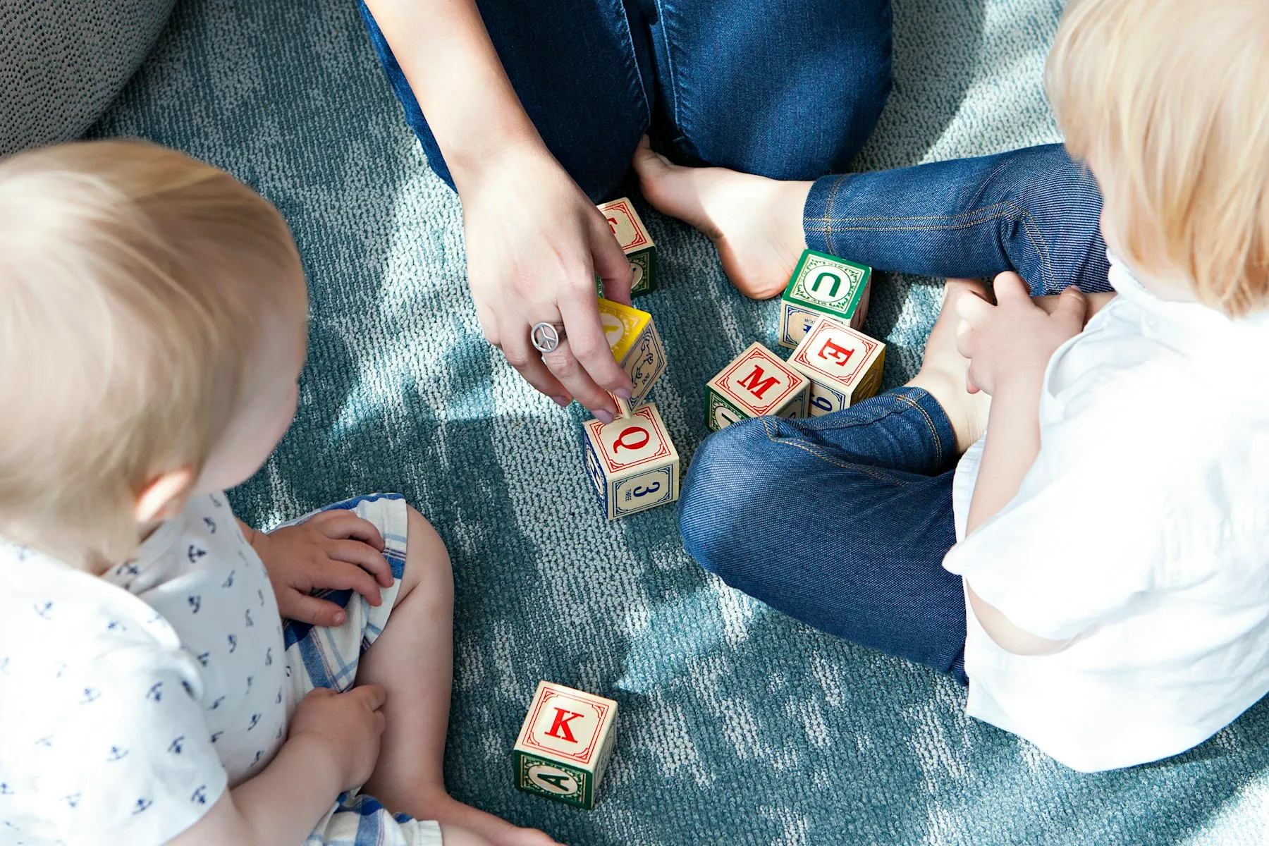A parent and child playing with a wooden shape sorter during an in-home ABA session.