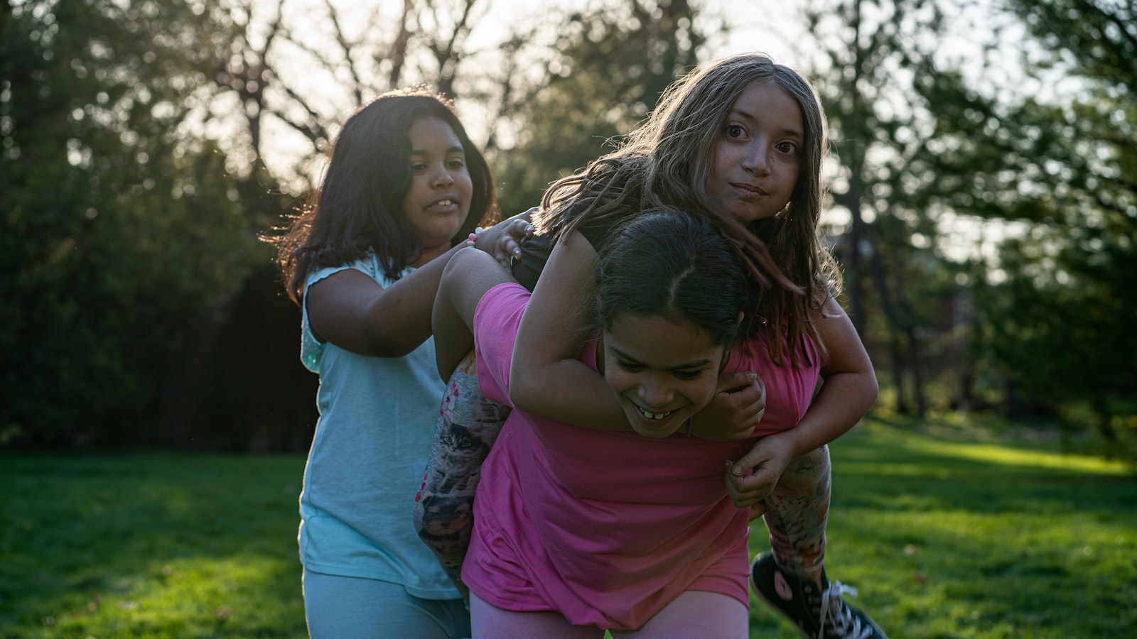 Niños jugando juntos en un parque al atardecer.
