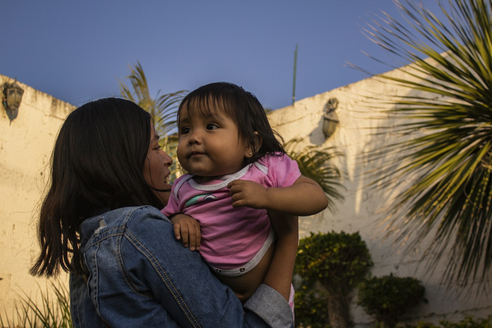 A mother and her young child sharing a warm moment together outdoors.