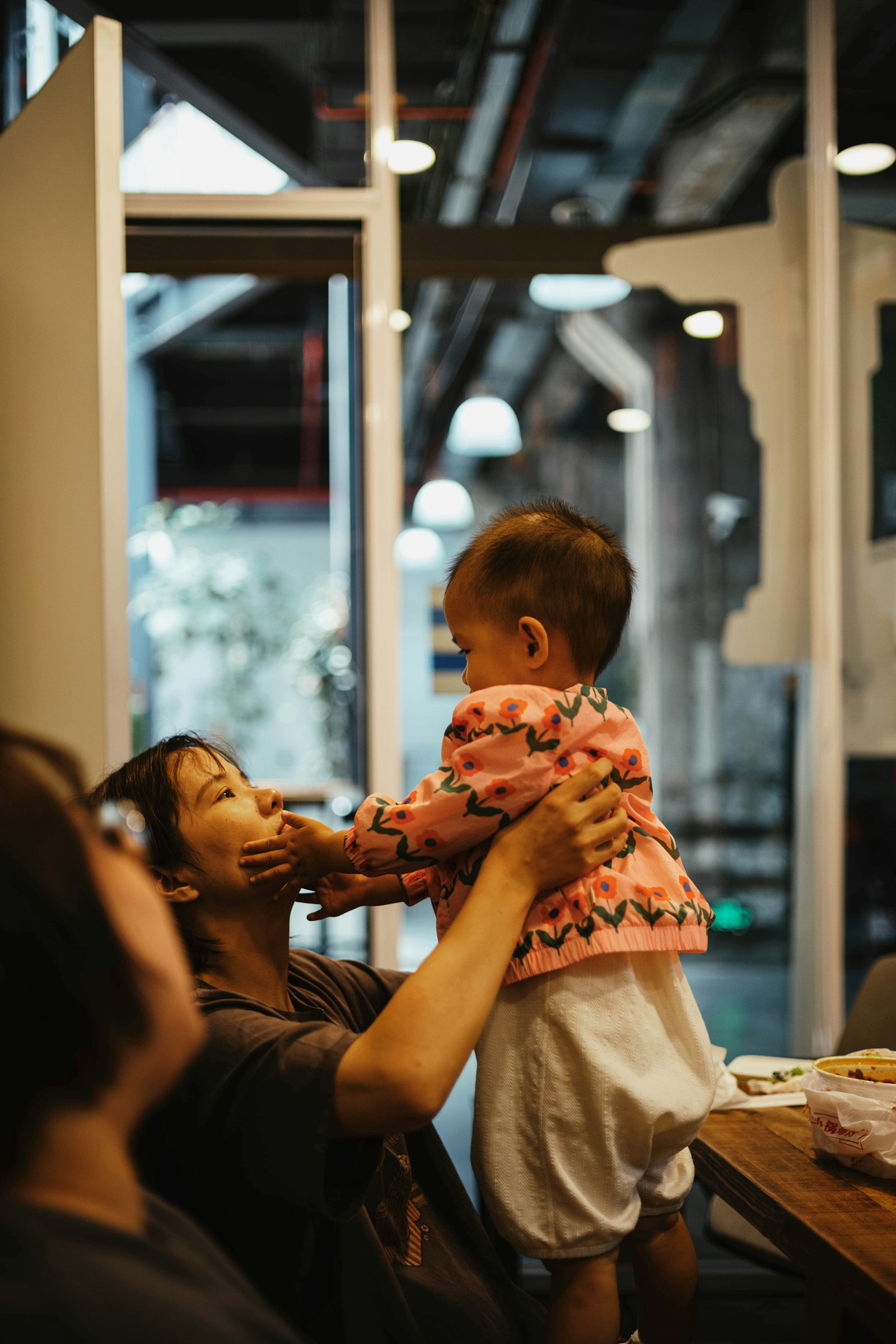 A parent and toddler sharing a playful moment together indoors.