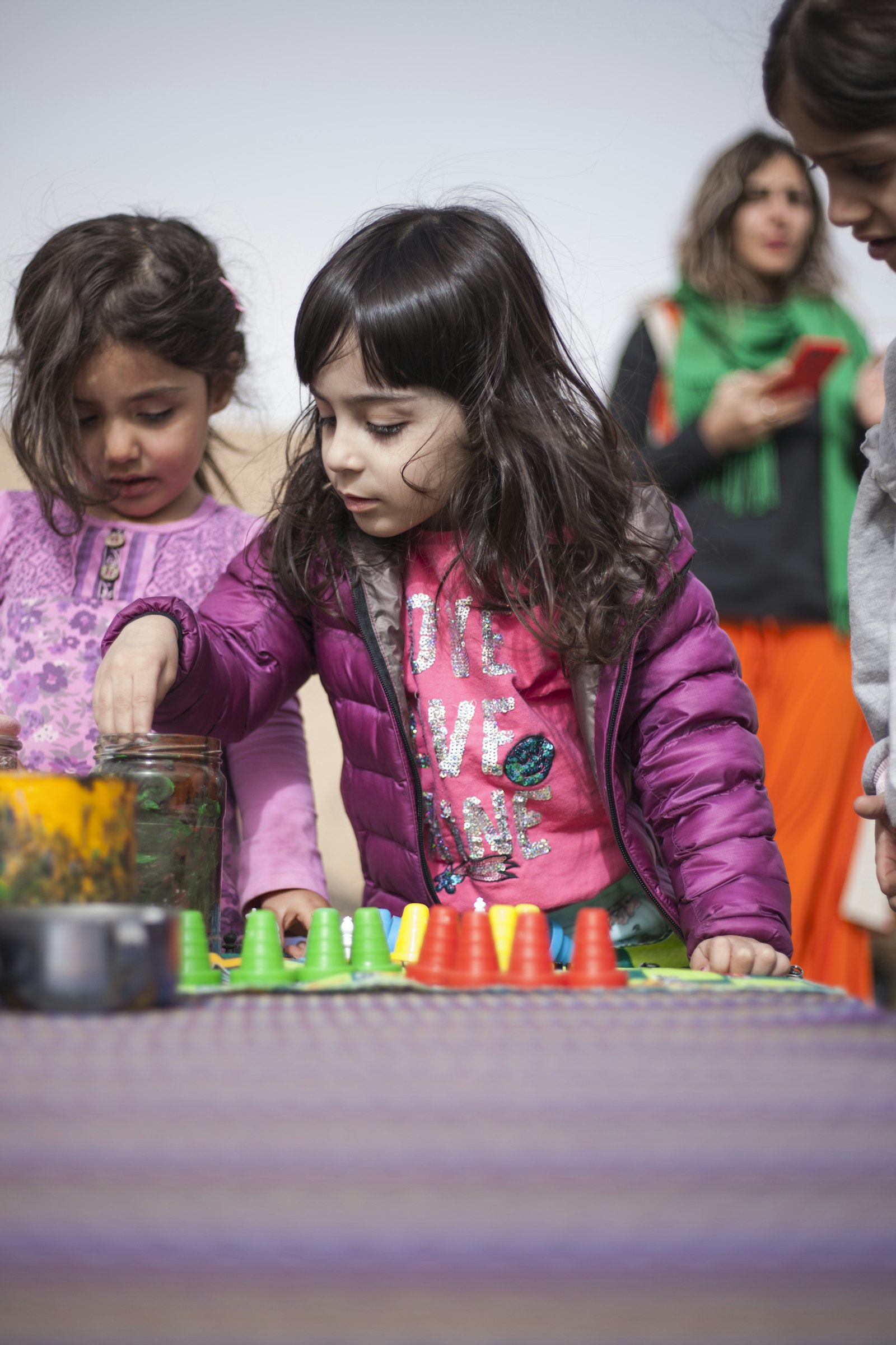 Young children focused on a hands-on sorting activity at a learning table.