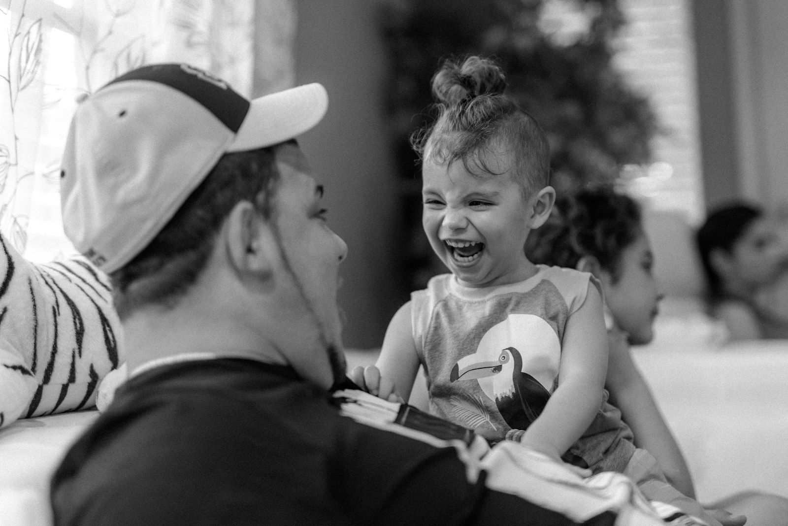 A father and his young daughter laughing together.