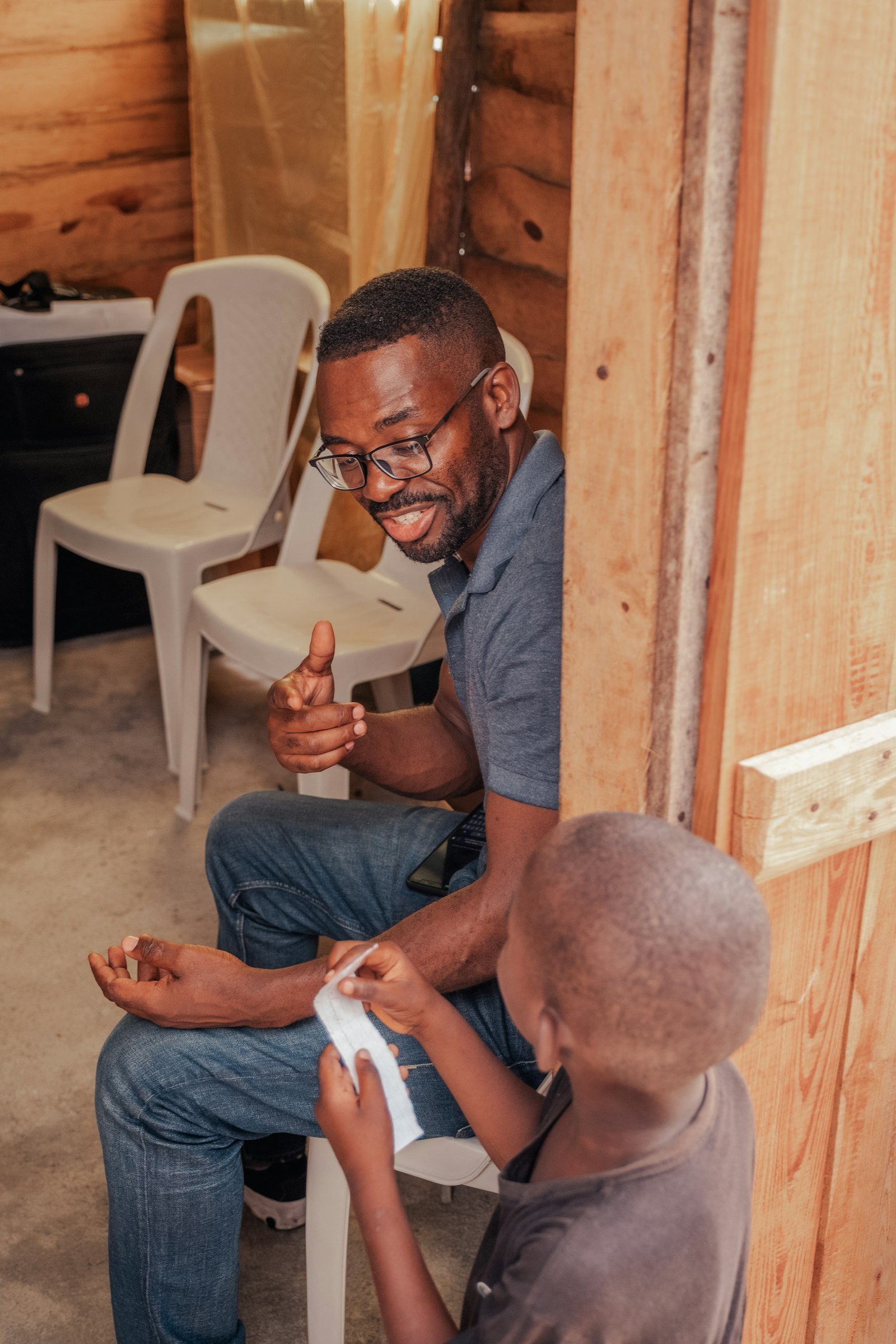 A father and his young son laughing together during a hands-on activity.