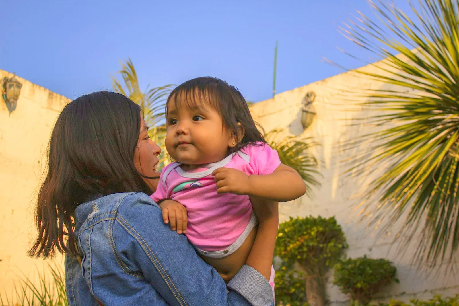 A mother and her young child sharing a warm moment together outdoors.
