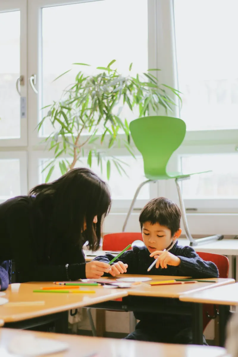 An adult and a young child drawing together at a table.