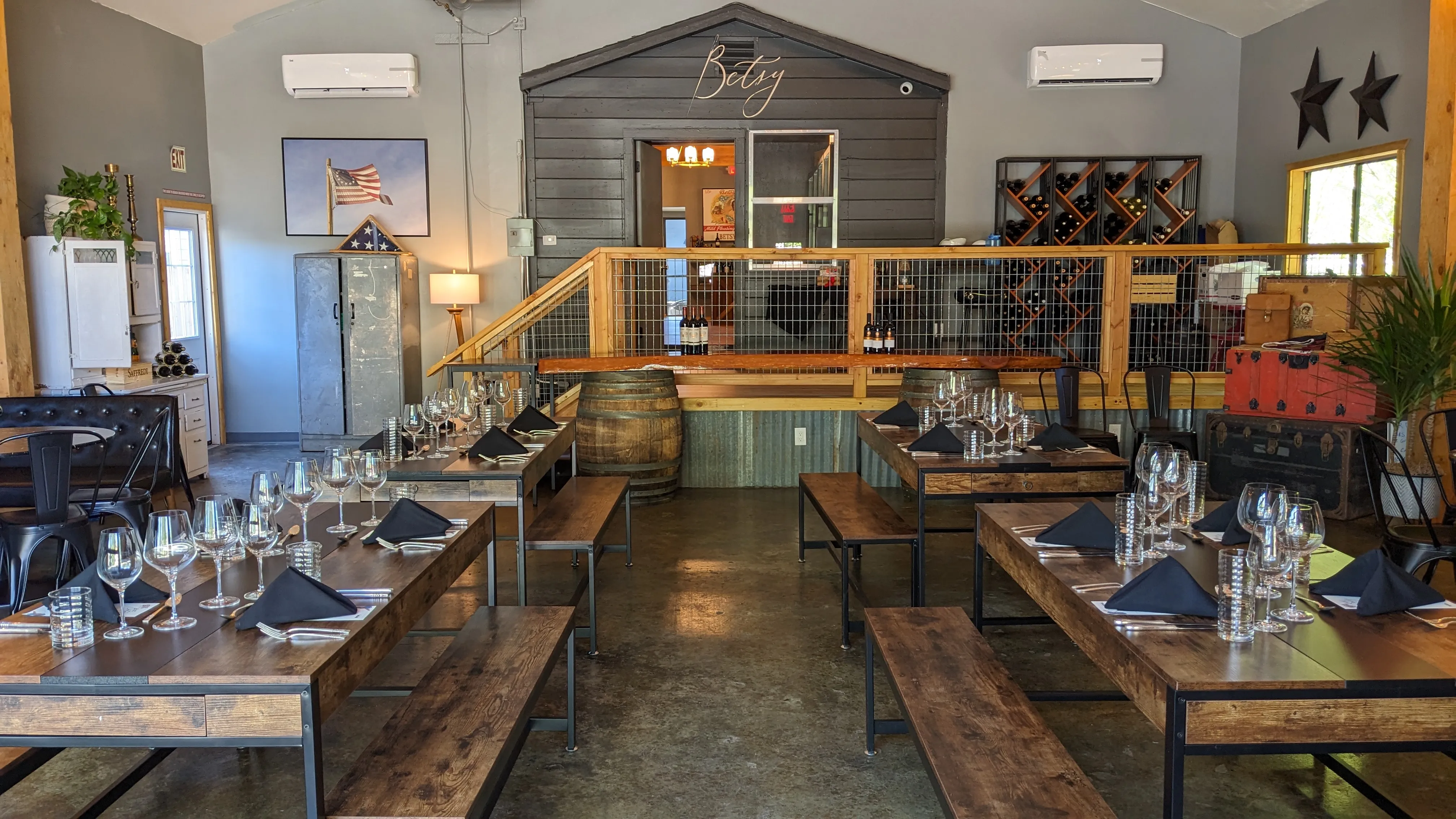 Tables and chairs set up with wine glasses ready on them in The Founders Room an event space at The Betsy.