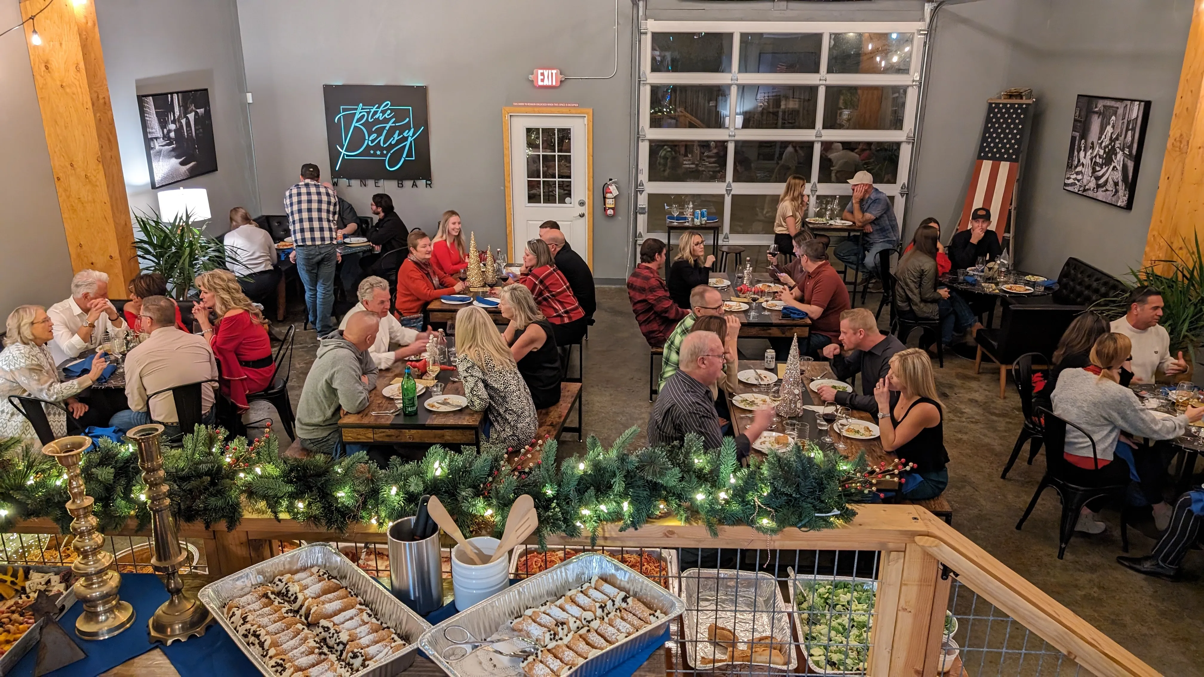 Large group dining and cheerings in The Founders Room during a special holiday party. The room is decorated in holiday cheer. 