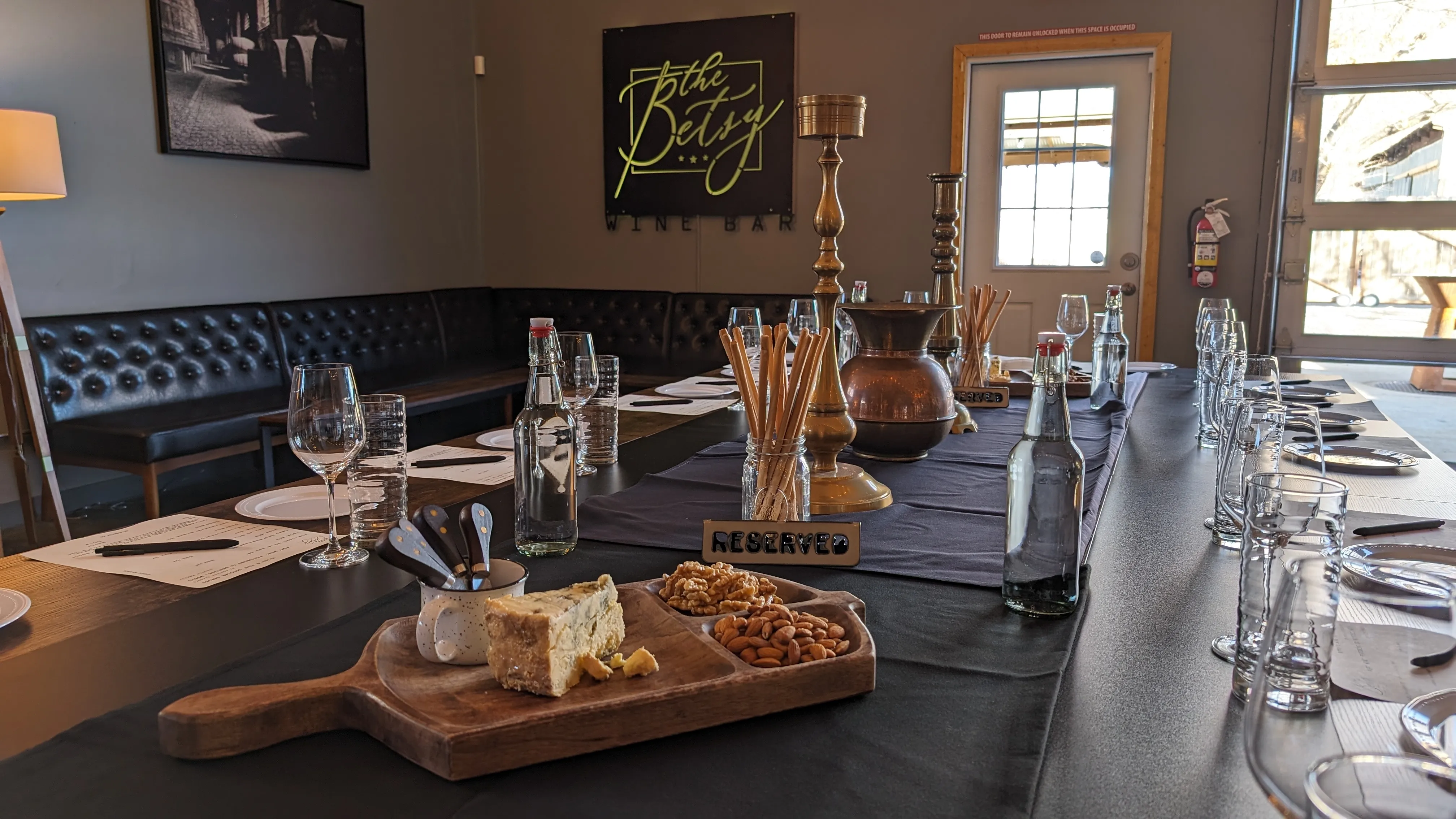 A special table set up in The Founders Room of The Betsy with wine glasses, meats and cheeses and more ready for the guests special event. 