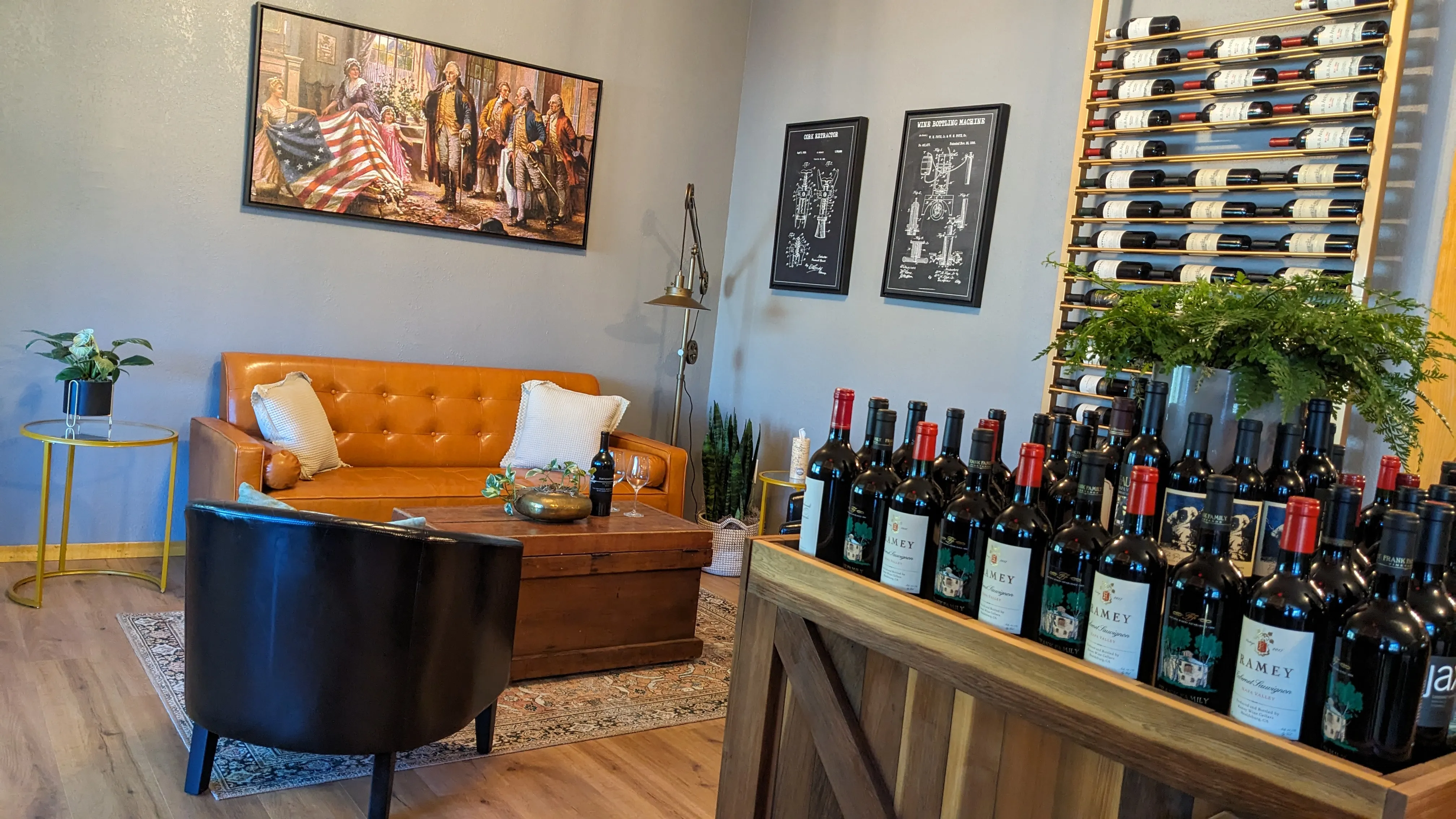 Cozy couch and chairs in the Liberty Lounge of The Betsy with wine bottles displayed all around on the walls and furniture.