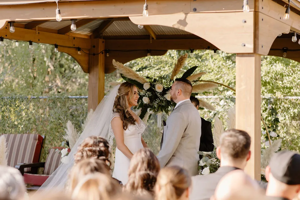A beautiful couple standing on The Starlight Patio of The Betsy for their wedding ceremony. Friends and family all seated watching them say their vows.