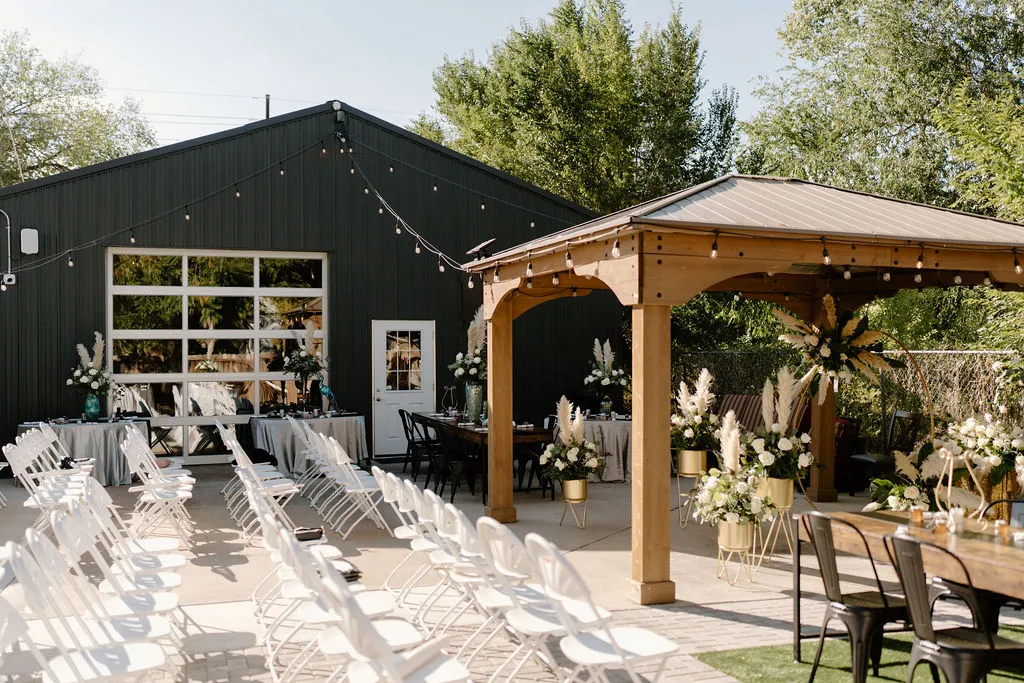Chairs set up in rows for a wedding on the Starlight Patio of The Betsy. Daytime with string lights and beautiful floral decor all around.