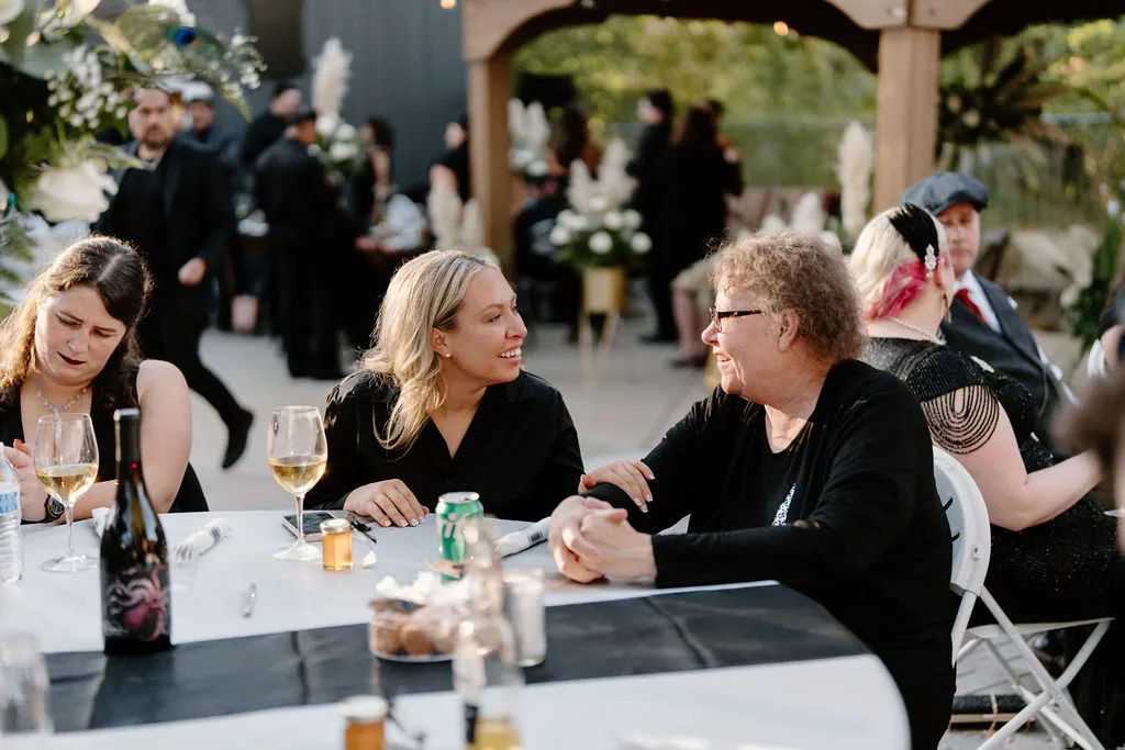 Table of gals talking to eachother and enjoying wine during an event on The Starlight Patio. 