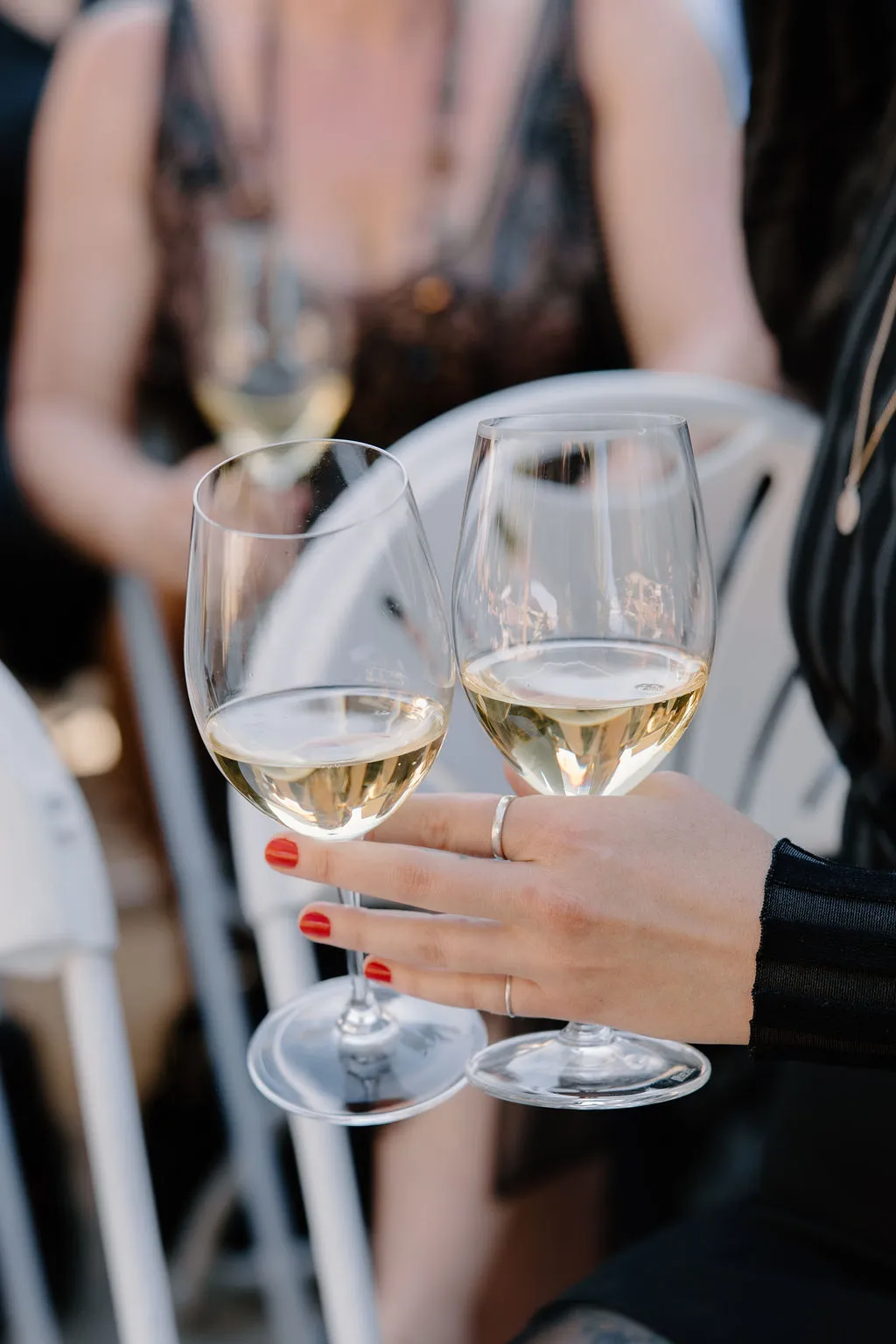 Two wedding guests toasting with glasses of white wine at The Betsy