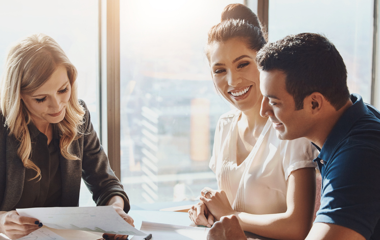 A couple reviewing their financial documents with their financial advisor