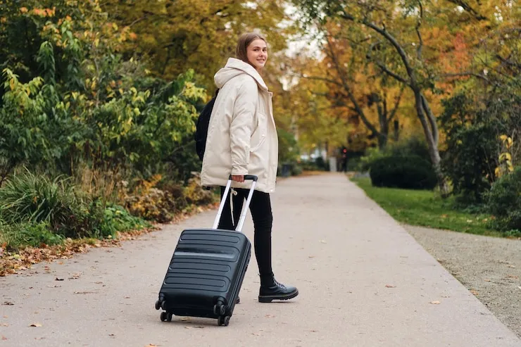 Femme traînant une valise, illustration du niveau C1 anglais nécessaire pour s’expatrier