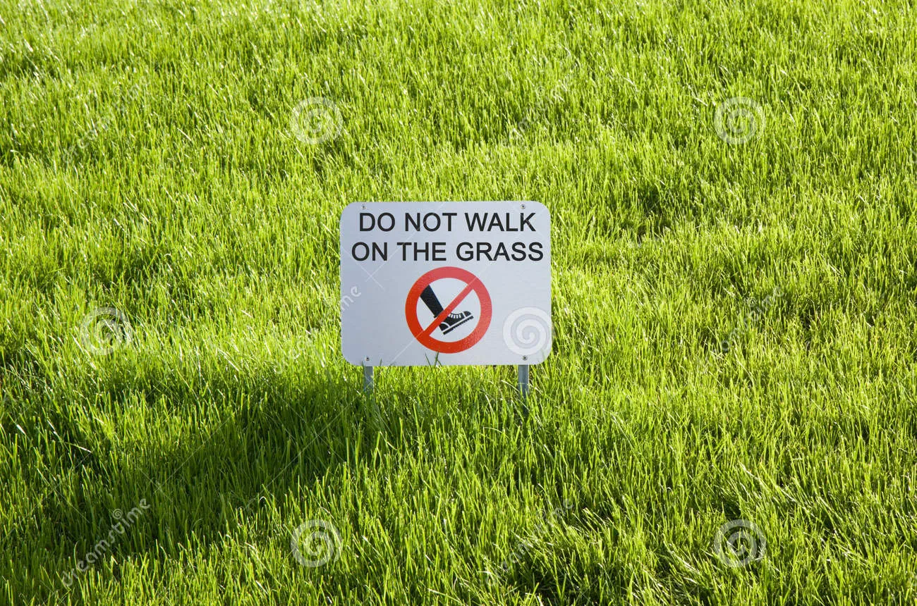 Panneau d'interdiction en anglais illustrant l'usage de l'impératif négatif : Don't walk on the grass