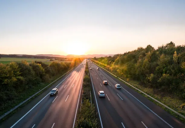 Auto auf Pendlerstrecke bei Sonnenaufgang