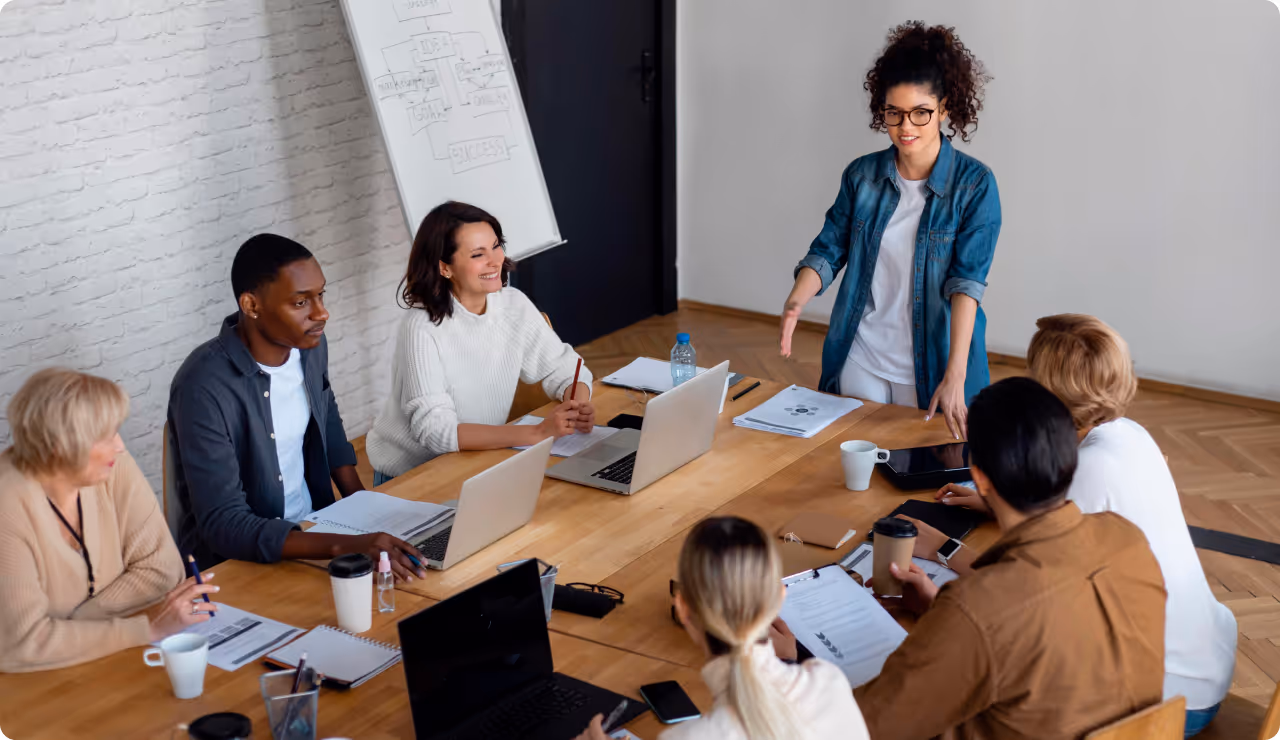 Manager animant une réunion d’équipe en présentiel, favorisant l’intelligence collective.