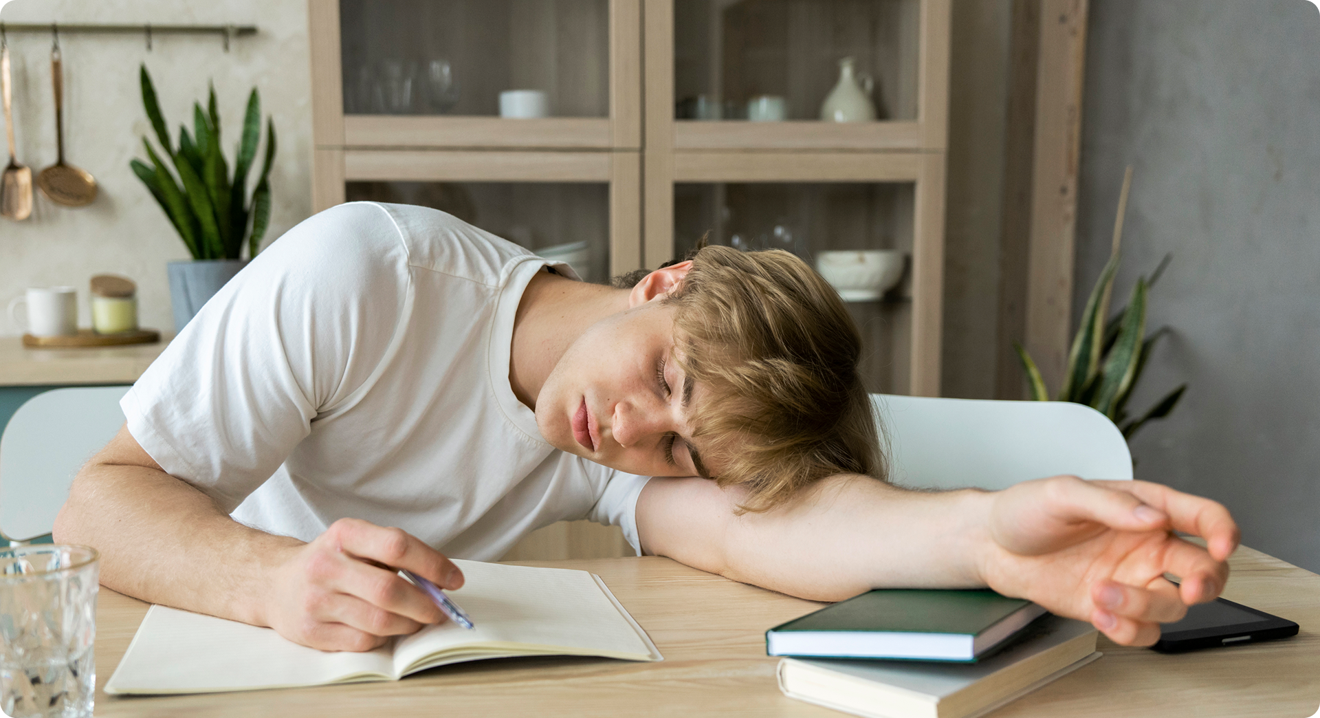 Apprenant endormi sur son bureau avec un cahier et un stylo, illustrant le concept d’apprentissage pendant le sommeil.