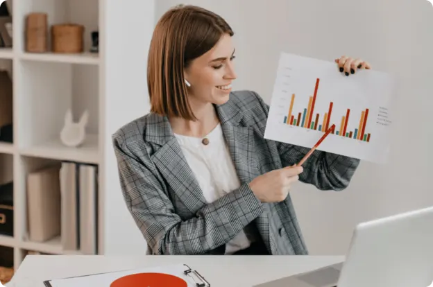 Collaboratrice présentant un graphique à l’écran pendant un échange en visio, illustrant un travail productif.